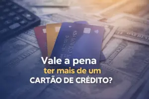 Cartões de crédito coloridos sobre dólares e calculadora ao fundo